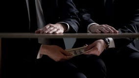 Politician hands taking bribe money under office table, lobbying of interests