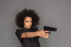 polizia Condizione della donna del mulatto isolata sulla pistola di tendenza grigia concentrata fotografie stock libere da diritti polizia Condizione della donna del mulatto isolata sulla pistola di tendenza grigia concentrata fotografie stock libere da diritti