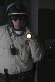 Polizist mit der Taschenlampe, die nachts patrouilliert Stockbild Polizist mit der Taschenlampe, die nachts patrouilliert Stockbild