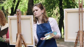 Poltava, Ucrania - puede 2019: Un grupo de mujeres de diversas edades est? aprendiendo dibujar im?genes en el parque almacen de metraje de vídeo Poltava, Ucrania - puede 2019: Un grupo de mujeres de diversas edades est? aprendiendo dibujar im?genes en el parque almacen de metraje de vídeo