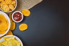 Pommes chips et casse-croûte sur la table noire d'ardoise, vue supérieure image stock Pommes chips et casse-croûte sur la table noire d'ardoise, vue supérieure image stock