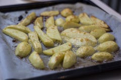 Pommes de terre épicées cuites au four avec l'ail et le beurre sur le parchemin, plan rapproché photos stock Pommes de terre épicées cuites au four avec l'ail et le beurre sur le parchemin, plan rapproché photos stock