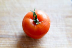 Pomodoro su un bordo di legno di taglio Pomodoro fresco wased per cucinare Pomodoro con le goccioline di acqua fotografie stock libere da diritti Pomodoro su un bordo di legno di taglio Pomodoro fresco wased per cucinare Pomodoro con le goccioline di acqua fotografie stock libere da diritti