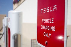 Pompes de station de charge de Tesla et signe indiqué photos libres de droits Pompes de station de charge de Tesla et signe indiqué photos libres de droits