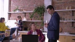 Pomyślna drużyna młodzi biznesmeni jest jedząca i pracująca z podczas robić pastylkami i laptopami w kuchni zbiory Pomyślna drużyna młodzi biznesmeni jest jedząca i pracująca z podczas robić pastylkami i laptopami w kuchni zbiory