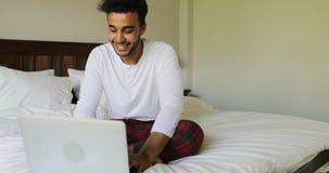 Pondering Man Using Laptop Computer Sitting On Bed Hispanic Guy Type Chatting Online In Bedroom Morning stock footage Pondering Man Using Laptop Computer Sitting On Bed Hispanic Guy Type Chatting Online In Bedroom Morning stock footage