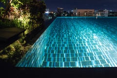 Pool at night with lush greenery and lighting for home design an stock photo Pool at night with lush greenery and lighting for home design an stock photo