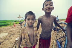 Poor cambodian kids playing with bicycle
