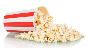 Popcorn spriddes från den stora randiga asken som isolerades på vit royaltyfri fotografi Popcorn spriddes från den stora randiga asken som isolerades på vit royaltyfri fotografi