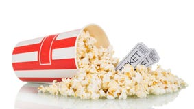 Popcorn spriddes ut boxas och filmbiljetter, på vit arkivfoto Popcorn spriddes ut boxas och filmbiljetter, på vit arkivfoto