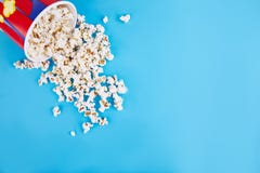 Popcorn wird auf einen blauen Hintergrund zerstreut Leerer Platz für Text stockbild Popcorn wird auf einen blauen Hintergrund zerstreut Leerer Platz für Text stockbild