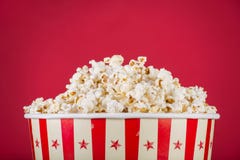 Popcorn στο αναδρομικό κιβώτιο που απομονώνεται στο κόκκινο υπόβαθρο στοκ φωτογραφία με δικαίωμα ελεύθερης χρήσης Popcorn στο αναδρομικό κιβώτιο που απομονώνεται στο κόκκινο υπόβαθρο στοκ φωτογραφία με δικαίωμα ελεύθερης χρήσης