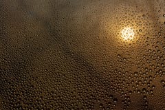 Por do sol através do vidro misted com gotas e gotejamentos imagens de stock Por do sol através do vidro misted com gotas e gotejamentos imagens de stock