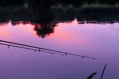 Por do sol reflexing da vara de pesca em um rio imagem de stock Por do sol reflexing da vara de pesca em um rio imagem de stock