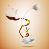 Porcelaine white cup with splashing coffee and milk liquid separated on brown background. Royalty Free Stock Images Porcelaine white cup with splashing coffee and milk liquid separated on brown background. Royalty Free Stock Images