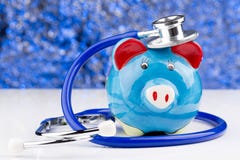 Porcellino salvadanaio con uno stetoscopio: costi medici fotografia stock Porcellino salvadanaio con uno stetoscopio: costi medici fotografia stock