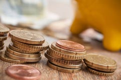 Porcellino salvadanaio giallo sulle euro monete e banconote sul wo Fotografia Stock Libera da Diritti Porcellino salvadanaio giallo sulle euro monete e banconote sul wo Fotografia Stock Libera da Diritti