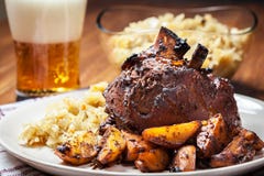 Pork knuckle with fried sauerkraut and baked potatoes Royalty Free Stock Photography Pork knuckle with fried sauerkraut and baked potatoes Royalty Free Stock Photography
