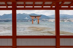 PORTA DE MIYAJIMA TORII ATRAVÉS DA JANELA DE MADEIRA VERMELHA, HIROSHIMA, JAPÃO foto de stock PORTA DE MIYAJIMA TORII ATRAVÉS DA JANELA DE MADEIRA VERMELHA, HIROSHIMA, JAPÃO foto de stock