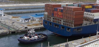 Portacontenedores con el barco del tirón foto de archivo libre de regalías Portacontenedores con el barco del tirón foto de archivo libre de regalías