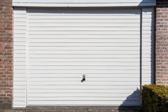 Porte blanche de garage d'une maison isolée photo stock Porte blanche de garage d'une maison isolée photo stock