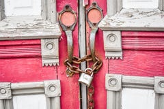 Porte rosse abbandonate della chiesa con la catena e la serratura Porte rosse abbandonate della chiesa con la catena e la serratura