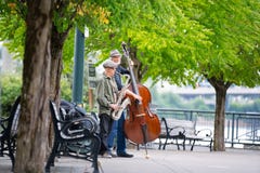 Two elderly gentlemen in a park with musical instruments. stock photos Two elderly gentlemen in a park with musical instruments. stock photos