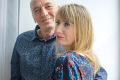 Portr?t der sexy Frau von mittlerem Alter, die Umarmung ihrer ?lteren Ehemann-Stellung nahe Fenster innerhalb ihres Hauses genie? stockfoto Portr?t der sexy Frau von mittlerem Alter, die Umarmung ihrer ?lteren Ehemann-Stellung nahe Fenster innerhalb ihres Hauses genie? stockfoto