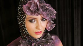 Portr?t eines stilvollen Haute Couture-M?dchenmodells mit den rauchigen Augen des ausdrucksvollen Makes-up, die im Studio auf ein stock video footage Portr?t eines stilvollen Haute Couture-M?dchenmodells mit den rauchigen Augen des ausdrucksvollen Makes-up, die im Studio auf ein stock video footage