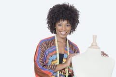 Portrait of African American female fashion designer with tailor's dummy over gray background royalty free stock image Portrait of African American female fashion designer with tailor's dummy over gray background royalty free stock image