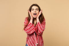 Portrait of amazed young woman in casual clothes keeping mouth wide open putting hands on face isolated on pastel beige royalty free stock photography Portrait of amazed young woman in casual clothes keeping mouth wide open putting hands on face isolated on pastel beige royalty free stock photography