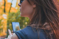 Portrait attractive of a brown-haired woman with a phone in her hand for a walk. Toned royalty free stock photography Portrait attractive of a brown-haired woman with a phone in her hand for a walk. Toned royalty free stock photography