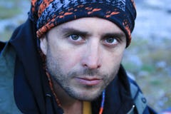 Portrait of an attractive young white Caucasian male tourist with a serious face and clear blue eyes in a tourist jacket and buff stock photos Portrait of an attractive young white Caucasian male tourist with a serious face and clear blue eyes in a tourist jacket and buff stock photos