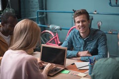 Smiling man situating near colleagues at desk royalty free stock photos Smiling man situating near colleagues at desk royalty free stock photos