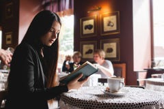 Portrait of a beautiful girl reading book in cafe. drink stock photos Portrait of a beautiful girl reading book in cafe. drink stock photos