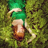 portrait of a beautiful red-haired pregnant girl in a green dress, lying in the grass with my eyes closed royalty free stock photography portrait of a beautiful red-haired pregnant girl in a green dress, lying in the grass with my eyes closed royalty free stock photography