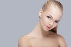 Portrait of beautiful young blonde woman with blue eyes on grey background. girl with clean skin stock photos Portrait of beautiful young blonde woman with blue eyes on grey background. girl with clean skin stock photos