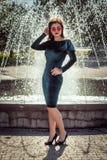 Portrait of beautiful young woman standing near fountain stock photos Portrait of beautiful young woman standing near fountain stock photos