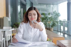 Portrait of beauty young Asian business woman analyzing paperwork or charts on the desk in office stock photos Portrait of beauty young Asian business woman analyzing paperwork or charts on the desk in office stock photos