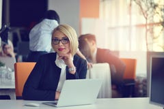 Portrait of a blonde female business partner in her 30`s sitting at her tidy desk in front of her computer. royalty free stock photo Portrait of a blonde female business partner in her 30`s sitting at her tidy desk in front of her computer. royalty free stock photo