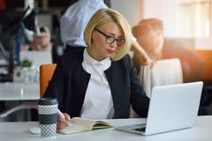 Portrait of a blonde female business partner in her 30`s sitting at her tidy desk in front of her computer. royalty free stock image Portrait of a blonde female business partner in her 30`s sitting at her tidy desk in front of her computer. royalty free stock image