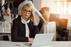 Portrait of a blonde female business partner in her 30`s sitting at her tidy desk in front of her computer. stock photos Portrait of a blonde female business partner in her 30`s sitting at her tidy desk in front of her computer. stock photos
