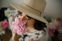 Portrait of boho girl smelling pink peony at pink and white peonies on rustic wooden floor. Stylish hipster woman in bohemian royalty free stock photos Portrait of boho girl smelling pink peony at pink and white peonies on rustic wooden floor. Stylish hipster woman in bohemian royalty free stock photos
