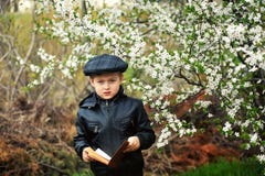 Portrait of a boy with a book in the spring blooming garden royalty free stock images Portrait of a boy with a book in the spring blooming garden royalty free stock images