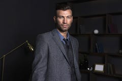Portrait of a brutal stylish man in a business suit. Elegant handsome man in the house. stock image Portrait of a brutal stylish man in a business suit. Elegant handsome man in the house. stock image