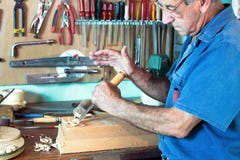Portrait of cabinetmaker carving a piece of wood with chisel and stock image Portrait of cabinetmaker carving a piece of wood with chisel and stock image