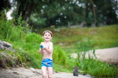 Portrait of caucasian little boy in straw hat playing toys and water pump on the beach. royalty free stock image Portrait of caucasian little boy in straw hat playing toys and water pump on the beach. royalty free stock image