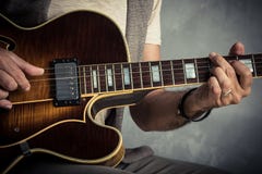 Portrait caucasien adulte de guitariste jouant la guitare électrique sur le fond grunge Fermez-vous vers le haut du détail d'inst photos libres de droits Portrait caucasien adulte de guitariste jouant la guitare électrique sur le fond grunge Fermez-vous vers le haut du détail d'inst photos libres de droits
