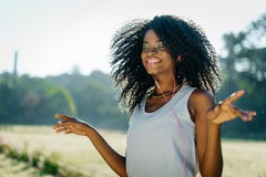 Portrait of the charming young african girl with green eye shadows and lovely smile enjoying the music in earphones on Royalty Free Stock Photos Portrait of the charming young african girl with green eye shadows and lovely smile enjoying the music in earphones on Royalty Free Stock Photos