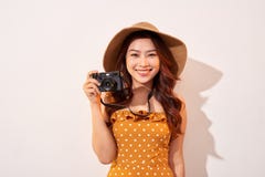Portrait of cheerful smiling young woman taking photo with inspiration and wearing summer dress. Girl holding retro camera. Model royalty free stock photo Portrait of cheerful smiling young woman taking photo with inspiration and wearing summer dress. Girl holding retro camera. Model royalty free stock photo